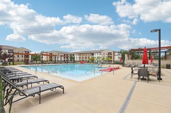 Resort style pool with a sun deck and grill area